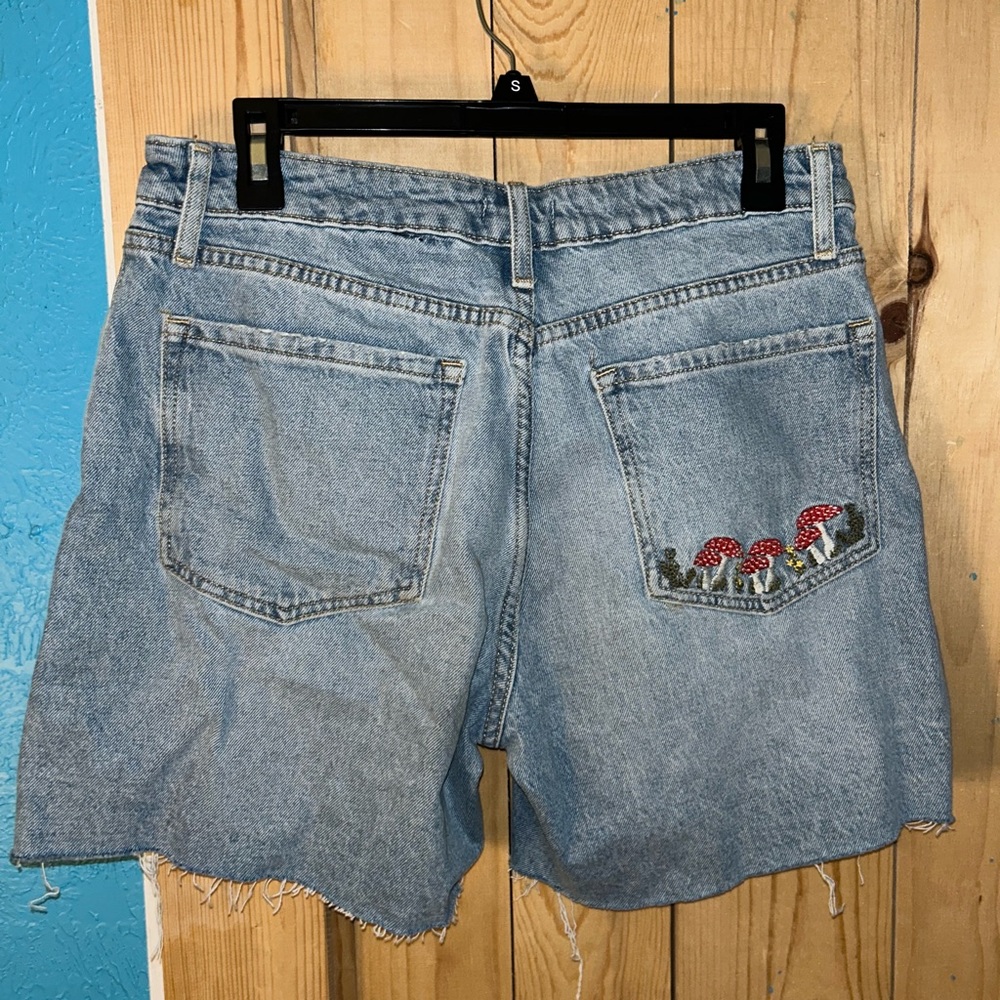 Blue denim shorts with mushroom embroidery on the back pocket